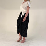 Black and white pinstripe high waisted sculptural skirt by Lumina Eligma
Architectural wool blend skirt with asymmetrical pleats
Designer black pinstripe skirt with modern tailoring
