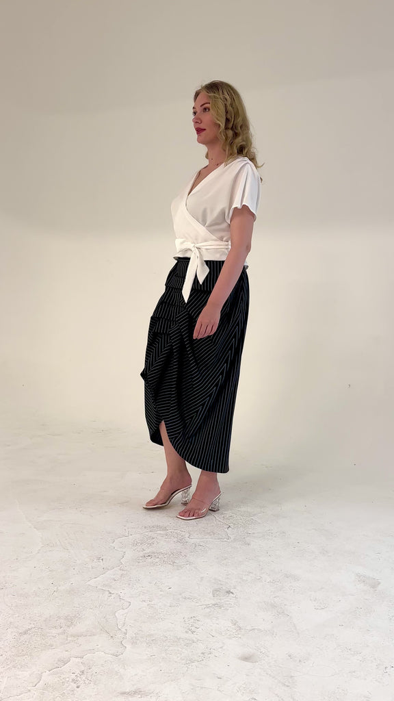 Black and white pinstripe high waisted sculptural skirt by Lumina Eligma
Architectural wool blend skirt with asymmetrical pleats
Designer black pinstripe skirt with modern tailoring
